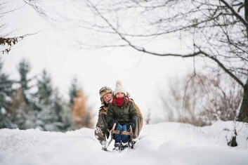 grandfather-and-small-girl-sledging-on-a-winter
